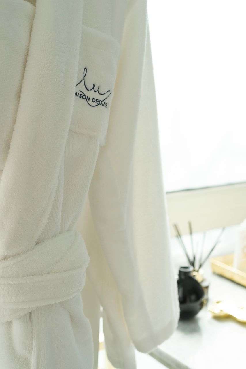 A white bathrobe with a logo on the sleeve.