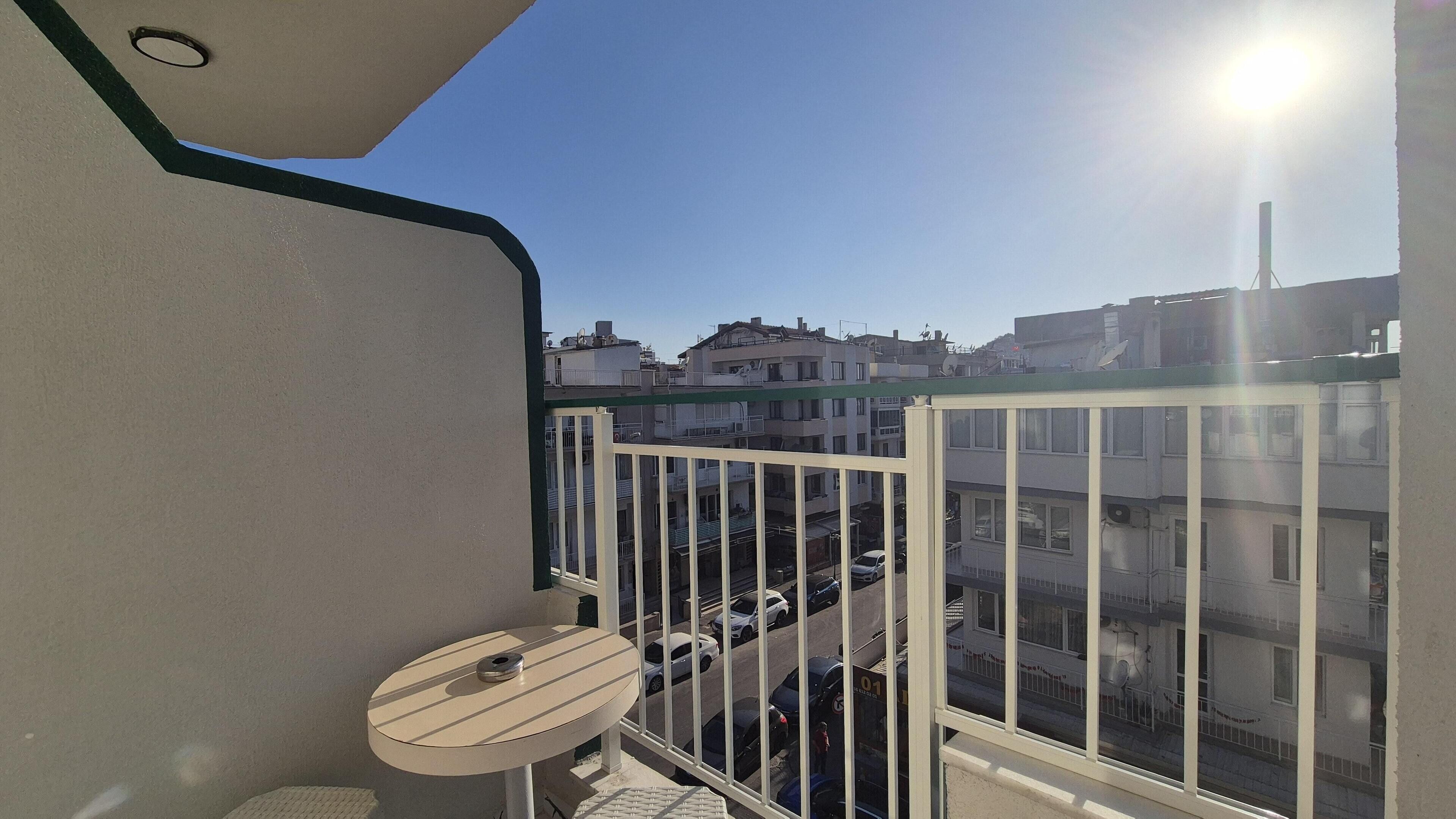 Un balcón con vistas a una zona residencial, una mesita y una silla.