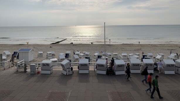 Une zone située au bord de la plage, avec des cabanes numérot ées et une vue sur l’océan.