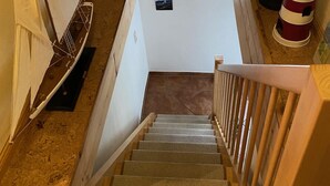 Un escalier avec une rampe en bois menant à un palier doté d’une fenêtre.