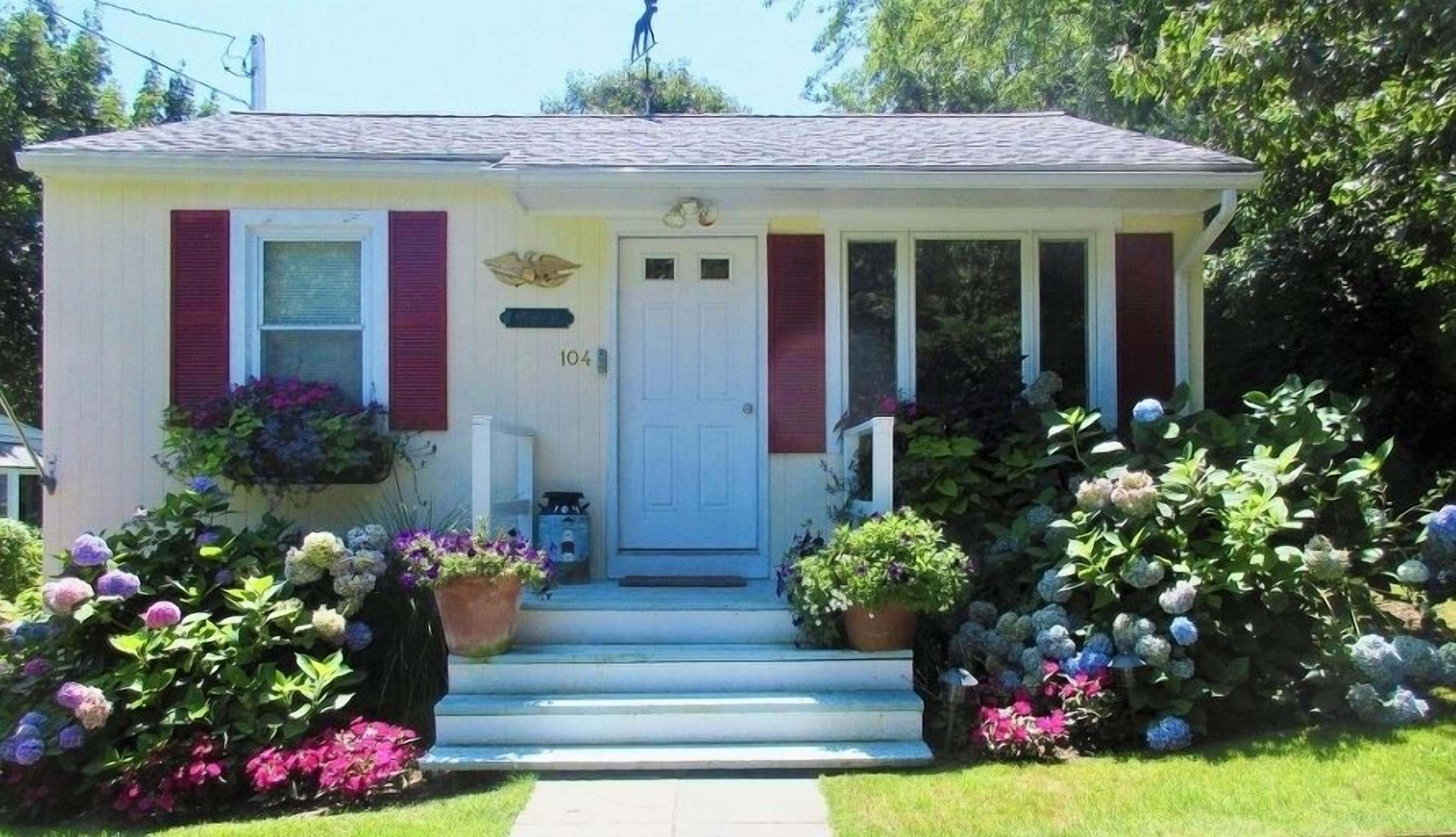A single-story house with a front porch, a white door, and a mailbox.