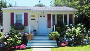 A single-story house with a front porch, a white door, and a mailbox.