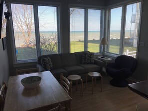 Una habitación con un ventanal, un sofá, una mesa de comedor y una silla.