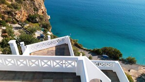 A staircase leading down to a coastal area with a view of the sea.