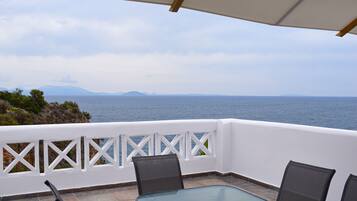 Enjoy breathtaking views of the water from this balcony with a glass table and four chairs.