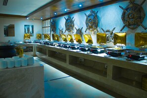 A buffet setup with multiple food stations, a marble counter, and decorative wall art.