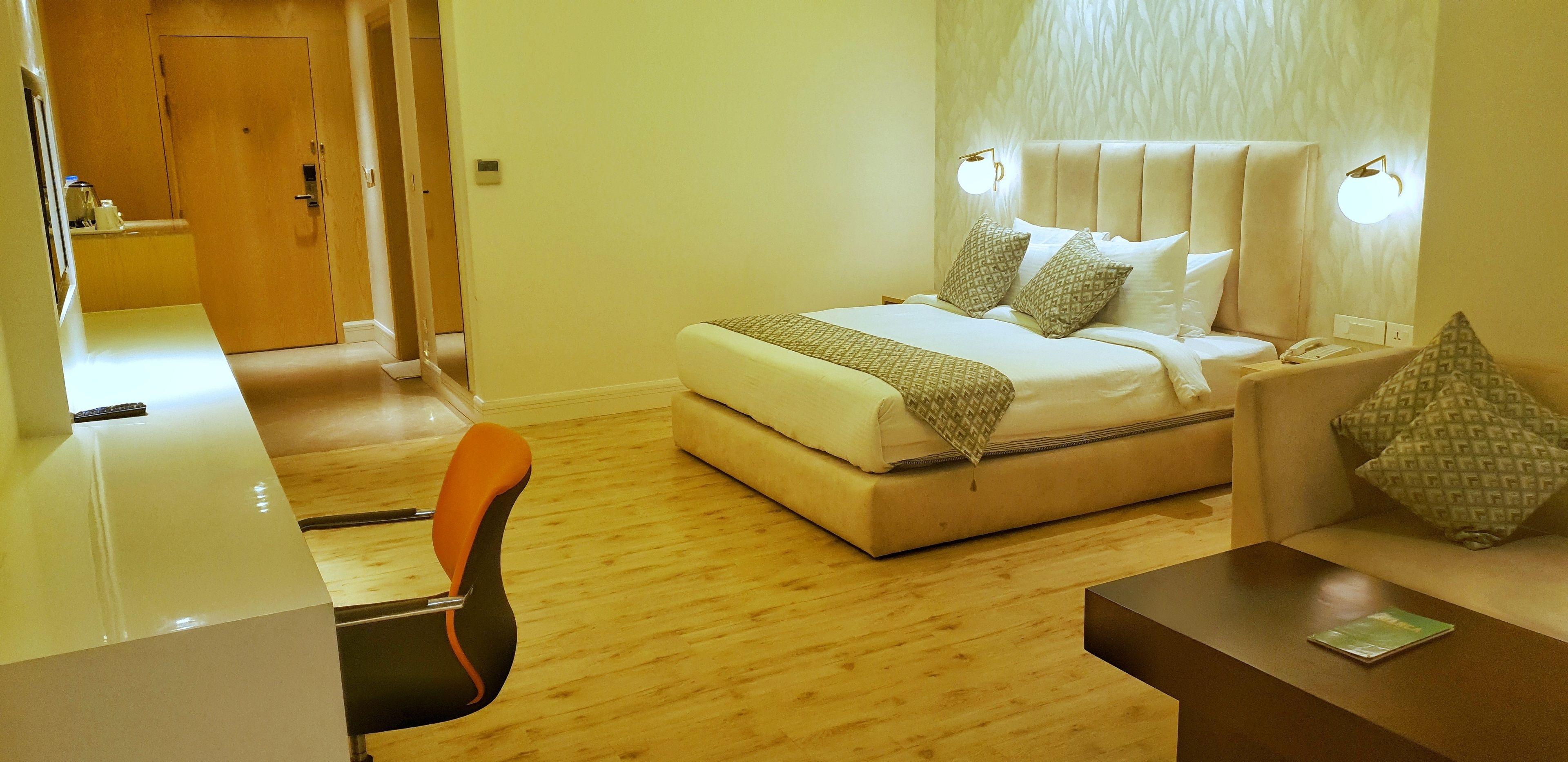 A hotel room with a bed, a desk, and a chair.