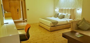 A hotel room with a bed, a desk, and a chair.
