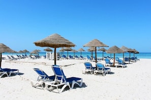 Plage privée, sable blanc, chaises longues, parasols