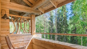 Puinen mökki, jossa on puinen penkki ja ikkuna, josta avautuu näkymä metsään.
