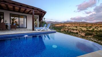 Piscina a l'aire lliure, para-sols i gandules