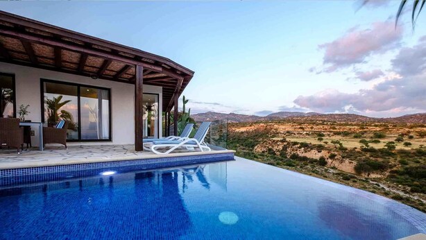 A modern villa with a private infinity pool overlooking a desert landscape. - Villa Thea (Pegeia)