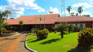 A hotel with a red-tiled roof, a windmill, and a well-maintained lawn with palm trees. - Estancia Park Hotel (Anapolis)
