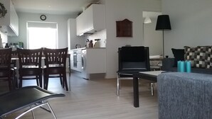 A modern apartment with a dining area, kitchen, and living space. - Hals Hotel Apartment (Hals)