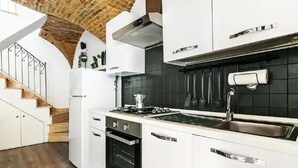 A modern kitchen with white cabinets, a black backsplash, and a wooden staircase. - Romantic historic house in Atri with a view of the Gran Sasso - CIN IT067004C2D739CXUO (Atri)