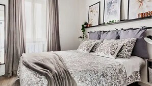 A bedroom with a bed, curtains, a bedside table, and wall art. - Romantic historic house in Atri with a view of the Gran Sasso - CIN IT067004C2D739CXUO (Atri)