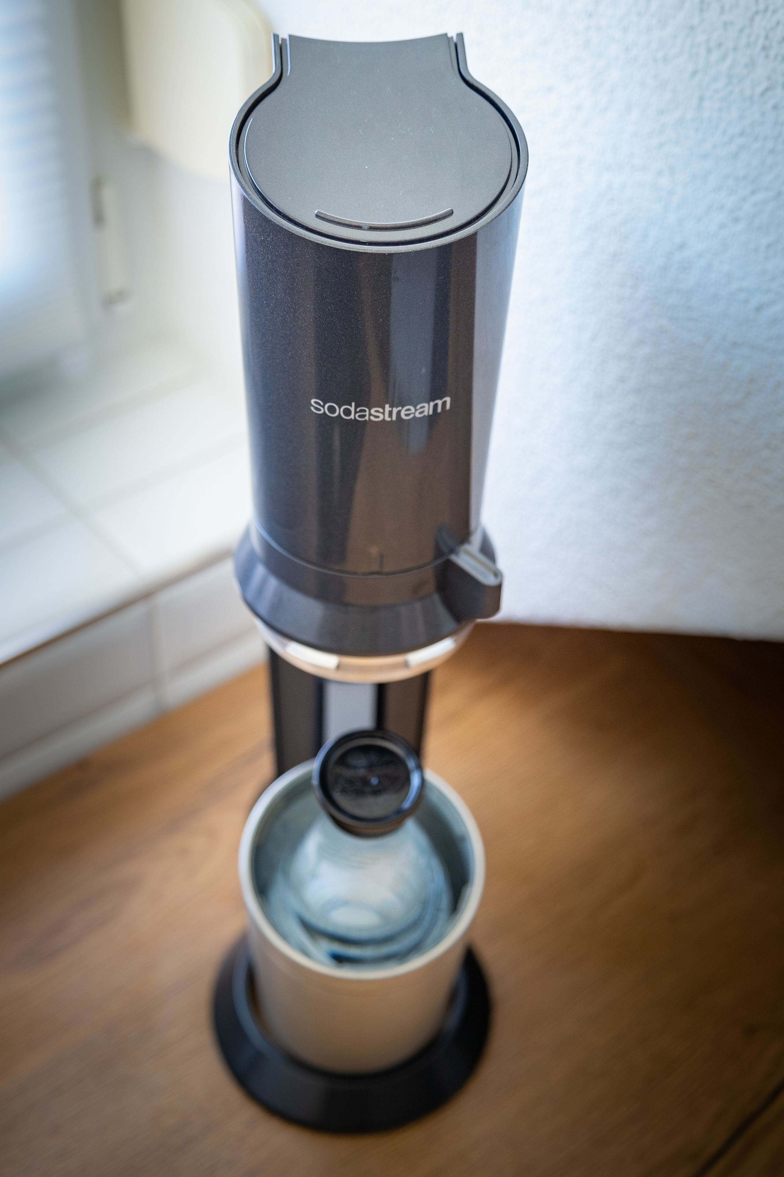 A coffee machine with a transparent water reservoir and a control panel.