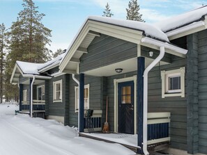 A two-story cabin with a covered porch and a front door. - Ylläskaira a by Interhome (Äkäslompolo)