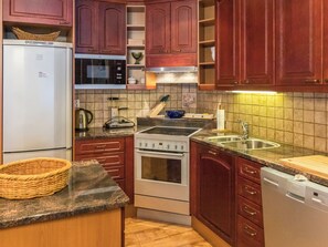 A kitchen with a refrigerator, microwave, stove, sink, and dishwasher.