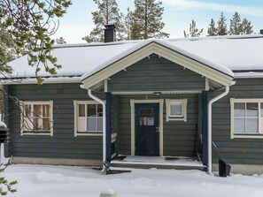 A two-story house with a front porch, a front door, and two windows with shutters.