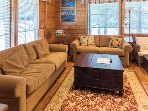 A cozy living room with two sofas, a coffee table, and a patterned rug.