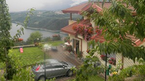 Ein Haus mit rotem Ziegeldach, einem eingezäunten Garten und einem geparkten Auto davor.