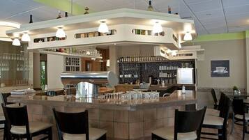 A modern coffee bar with a counter, seating area, and various coffee-making equipment.