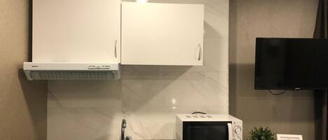 A compact kitchen with a sink, a microwave, and a built-in oven.