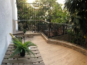 A wooden staircase with a metal railing leading to a balcony.