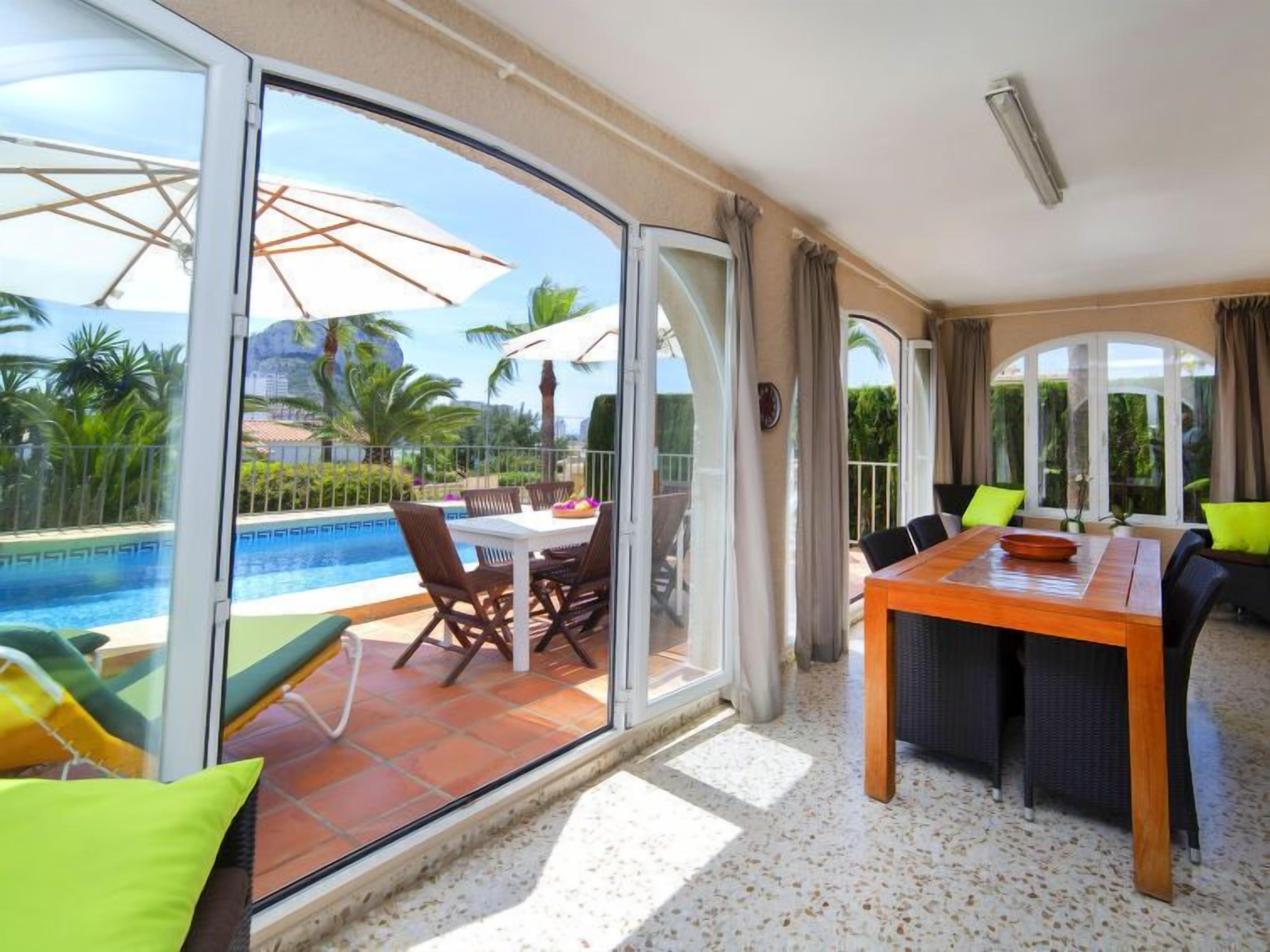 A spacious balcony with a pool, dining area, and seating.