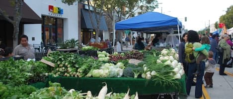A street market with various fresh vegetables on display.