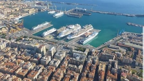 An aerial view of a coastal city with a marina, buildings, and a clear blue sea. - La finestra sul porto (Palermo)