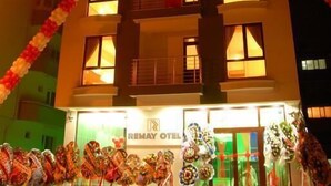 Un hotel con fachada moderna, varios balcones y una entrada bien iluminada.