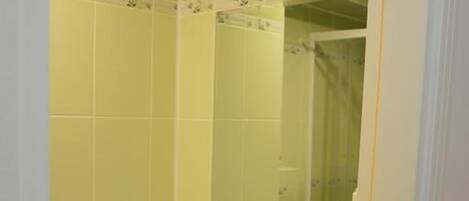 A bathroom with a white sink, a mirror, and a toilet paper holder.