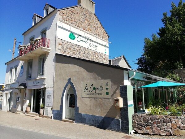 A hotel named Saint-Quay with a stone facade and a balcony with red railings. - Hotel Saint-Quay (Saint-Quay-Portrieux)
