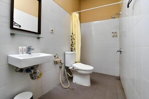 Een badkamer met een witte wastafel, toilet en douche.