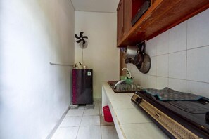 Une cuisine équipée d’un réfrigérateur, d’un ventilateur et d’une cuisinière.