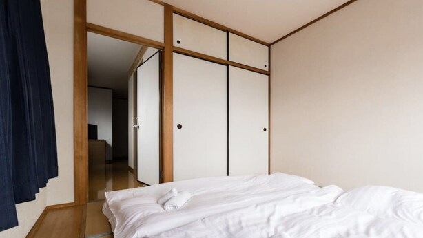 Una habitación de hotel con una cama, un armario y un espejo.