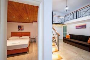 A bedroom with a wooden ceiling, a bed, and a nightstand. - Crown Deluxe Apartments (Sarande)