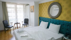 A hotel room with a large bed, two chairs, a small table, and a round mirror on the wall. - My Way Teras Butik Otel (Adalar)