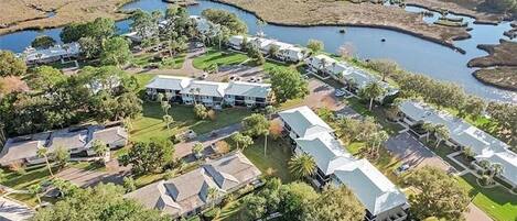 Vista aérea de una zona residencial con casas, un campo de golf y una masa de agua.