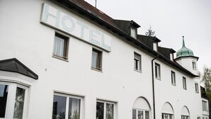 Um edifício branco com uma placa na fachada que diz "HOTEL".