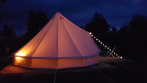 A tent-like structure with a conical roof, illuminated by warm lighting. - Camping La Tourelle (Plémy)