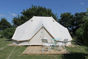 A large, white tent with a wooden deck and two white folding chairs. - Camping La Tourelle (Plémy)