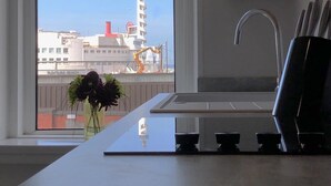 A kitchen with a large window, a sink, and a vase with flowers. - The Place Blackpool (Blackpool)