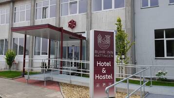 Ein Hotel Eingang mit einem Schild, das das Ruhr Inn Hattingen kennzeichnet und ein Hotel sowie eine Jugendherberge anbietet.