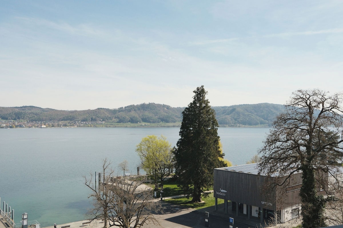 A lakeside view with a building labeled 'bodano' and a clear sky.
