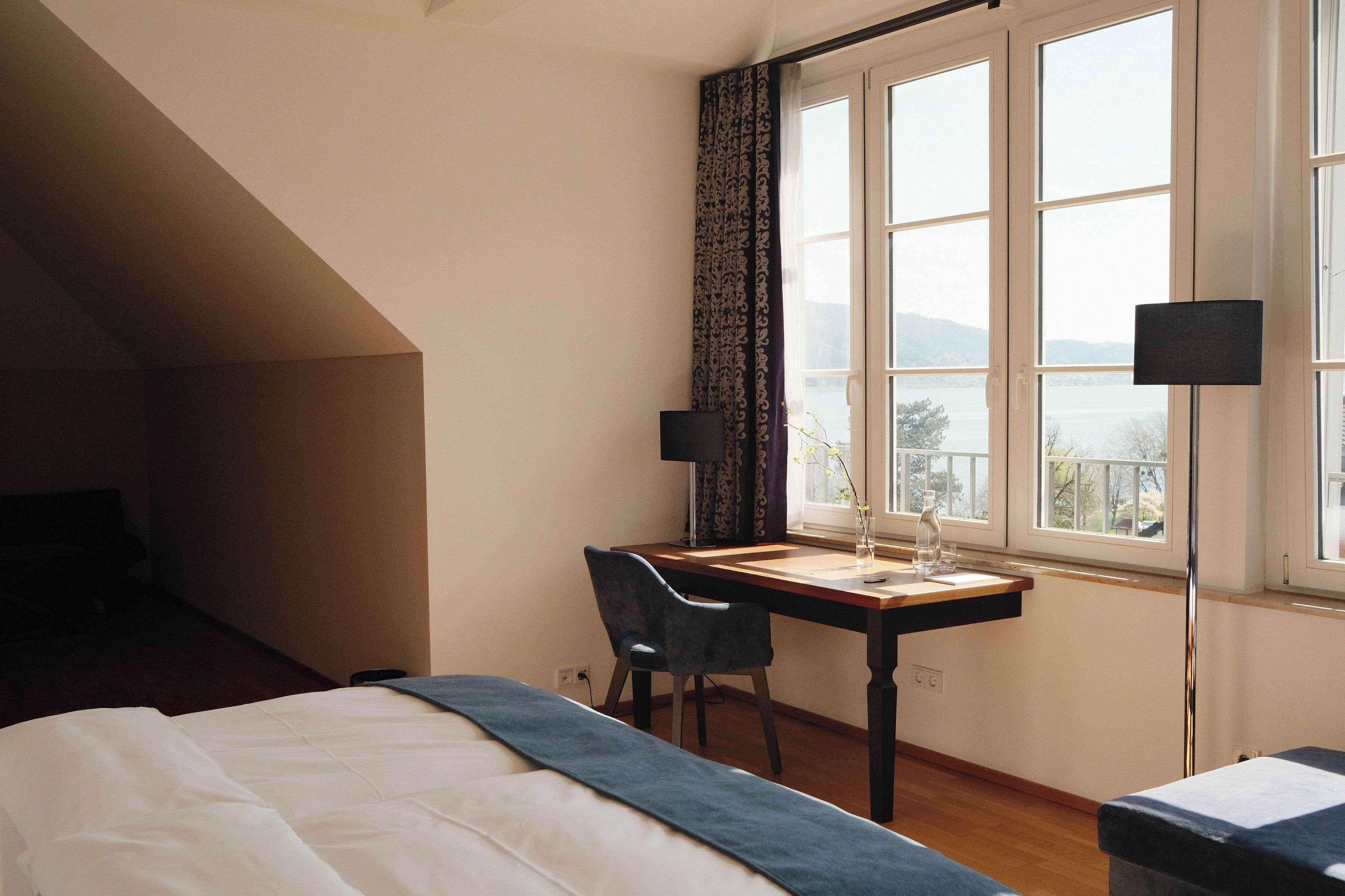 Una camera da letto con un letto, una scrivania, una sedia, una lampada e una finestra vista.