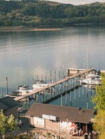 Un puerto deportivo con barcos amarrados, un muelle de madera y un edificio con un letrero.