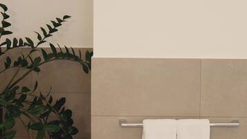 Un baño con un perchero, una planta y una pared con azulejos.